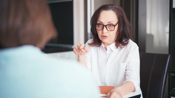 Middleaged Old Businesswoman Manager Mentor Speaking to a Client