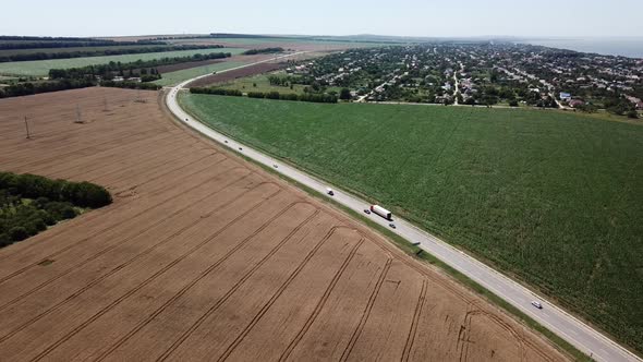 Aerial View of Highway Road Between Meadow and Agricultural Field