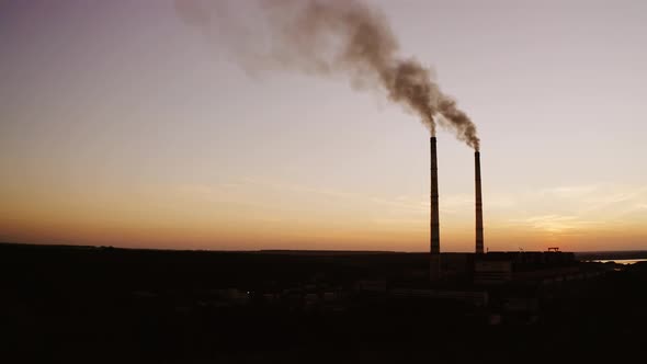 Highly polluting factory plant. Smoke from the pipes of plant at sunset
