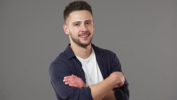 Portrait of Masculine Handsome Man Appearing at Camera and Standing with Arms Folded Isolated Over