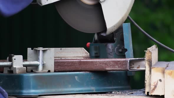 Welder Cut Metal Saw with Orange Spark Material. Man Use Tool for Sawing Closeup