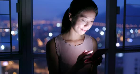 Woman working on cellphone at night 