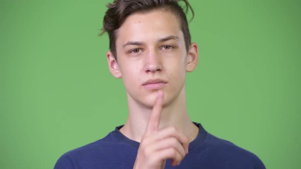 Young Handsome Teenage Boy with Finger on Lips