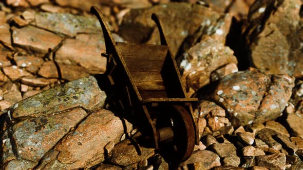 Abandoned Wooden Mine Wheelbarrow on Rocks