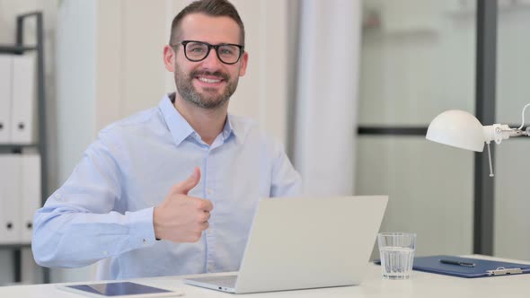 Thumbs Up Sign By Middle Aged Man with Laptop