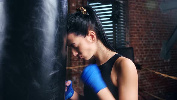 Displeased Mma Brunette Girl Wearing Blue Protective Wrapped Tapes on Hands Tired at Training