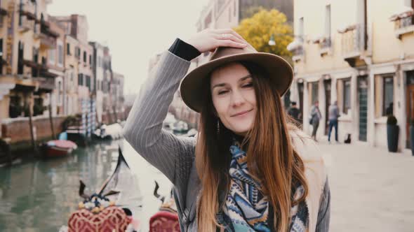 Close-up Portrait of Happy Young Beautiful European Woman Tourist in Hat Smiling Standing By Famous