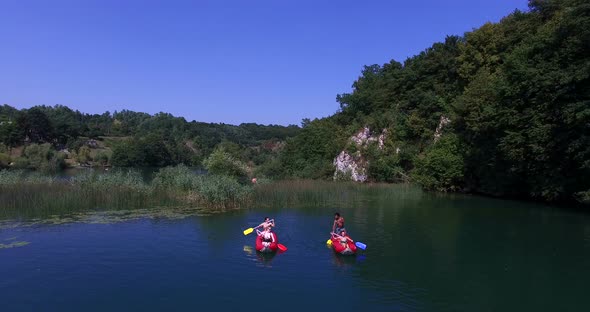 Aerial view of friends having fun paddling canoe