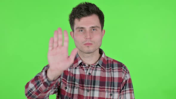 Portrait of Young Man Showing Stop Sign Green Chroma Screen