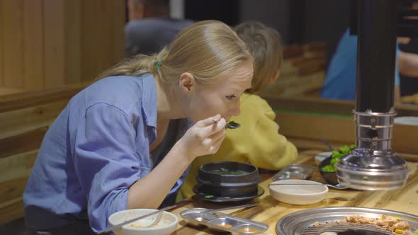 Family Visits a Korean Grill Restaurant Where You Can Cook Your Own Food. Travel To Korea Concept