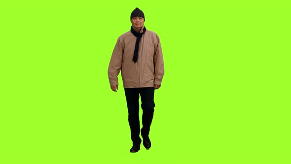 Man in Brown Jacket Walks on Green Background