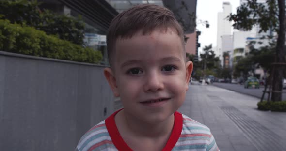 Young Happy Cute Kid Child with Pretty Face Standing on the Street