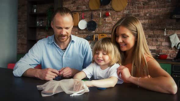 Young Spouses and Their Kid in Casual Outfit are Smiling and Playing a Game with Geometric Shapes