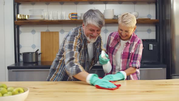 Senior Couple Cleaning Counter Top in Kitchen Together