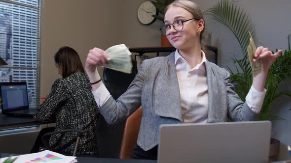 Businesswoman Company Manager Celebrating Success Dancing with Stack of Money Dollar Cash in Office