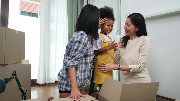Happy asian women LGBT lesbian couple holding boxes entering new modern house