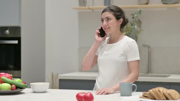 Young Indian Woman Talking on Smartphone While Sitting on Yoga Mat