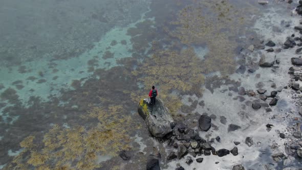 Drone Over Hiker Standing On Rock In Fjord