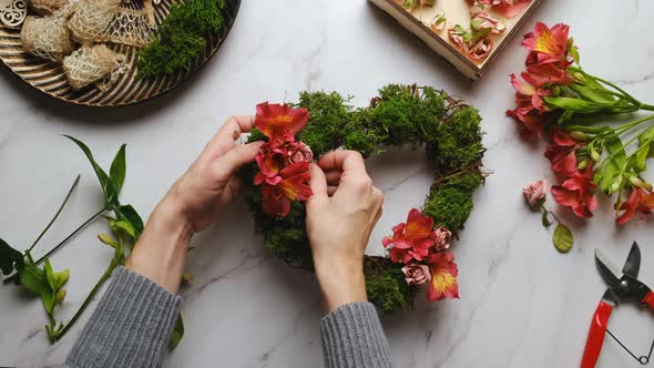 Hands Decorates Floral Wreath for Valentines Day