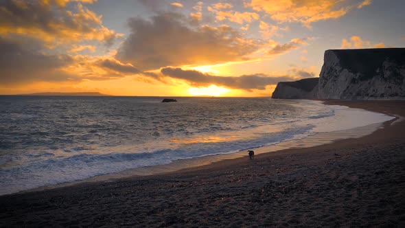 Durdle Door beach on the Jurassic Coast near Lulworth in Dorset, England with colorful dramatic sky.