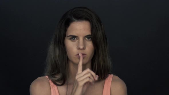 Woman holding finger to lips in silence