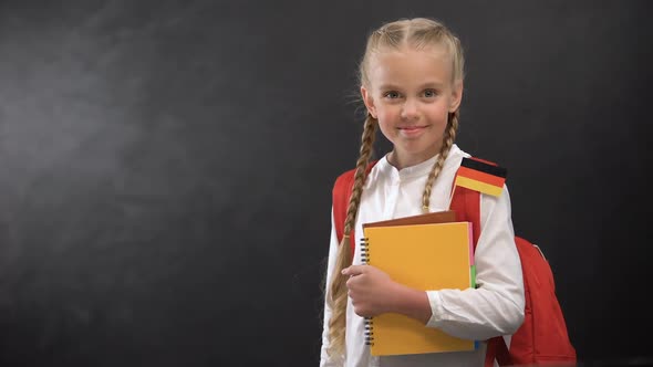 Happy Schoolgirl Holding Books With German Flag Ready to Learn Foreign Language