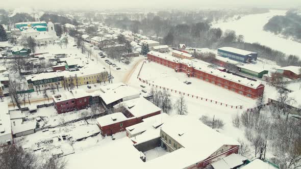 Snowy Winter Cityscape with Small Houses and a River Aerial View