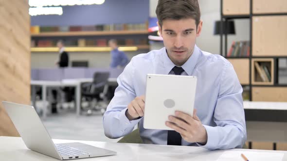 Businessman Reacting to Loss on Tablet