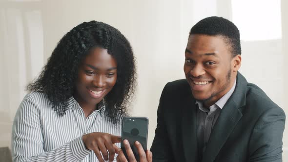 African American Millennial Students or Mixed Race Businesspeople Holding Smartphone Looking at