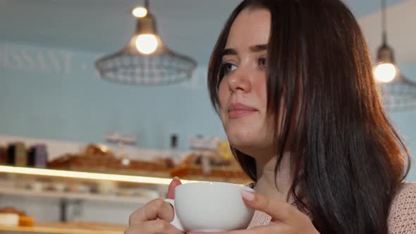 Low Angle Shot of a Beautiful Woman Smiling To the Camera, Holding Cup of Coffee