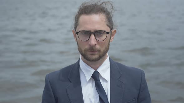 Portrait of Confident Caucasian Man in Eyeglasses at the Background of River Waves. Close-up of