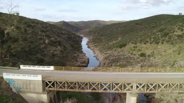 Aerial drone view of a bridge near Mertola with Guadiana river with a camping van passing by