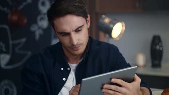 Sad Businessman Reading Bad News on Tablet Computer at Home Office