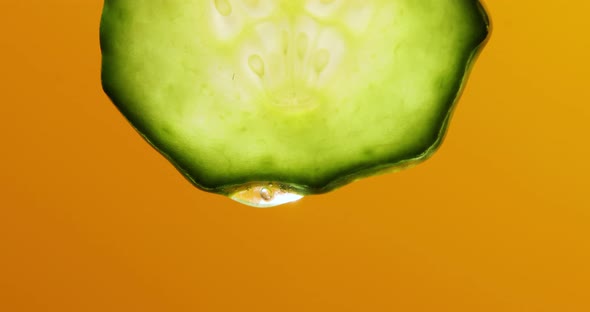 Gel, juice drips from cucumber slices with gel on yellow background