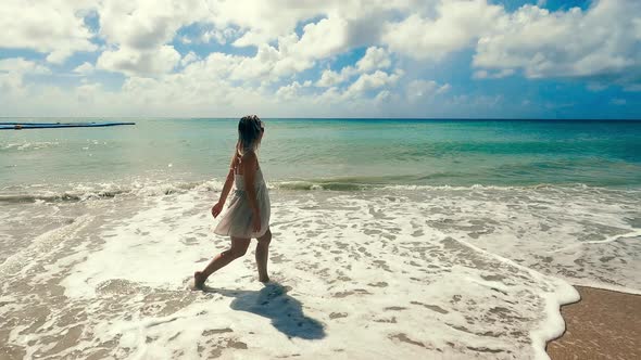 Care-free Lady Is Walking Along the Shore at Low Tide