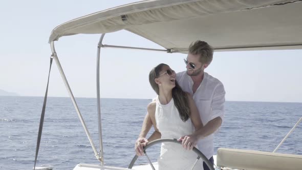 Couple Steering Their Yacht Together Slow Motion