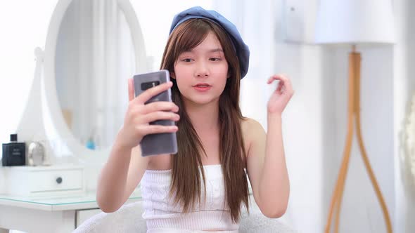 Portrait of young asian woman review cosmetics product fan following channel
