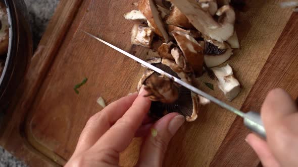 Fresh Portobello Mushrooms Being Cut On Chopping Board. overhead, vertical shot