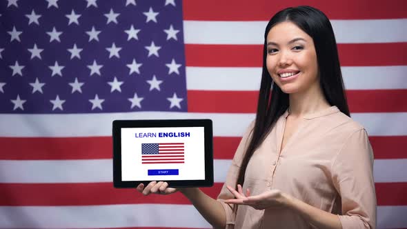 Lady Holding Tablet With Learn English App, USA Flag on Background, Education