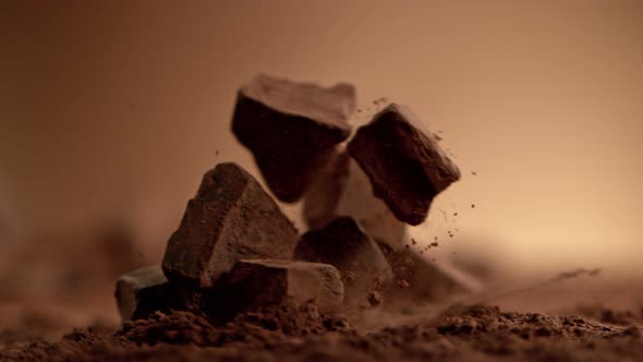 Super Slow Motion Shot of Raw Chocolate Chunks Falling Into Cocoa Powder at 1000Fps.