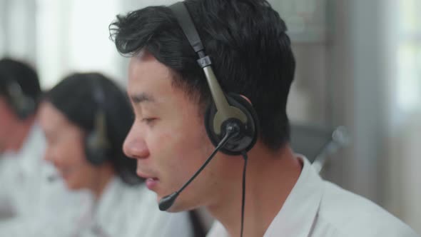 Close Up Of An Asian Man Call Centre Agent Speaking To Customer On The Call During Woking