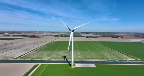 Dutch landscape with typical wind turbines and a water canal.