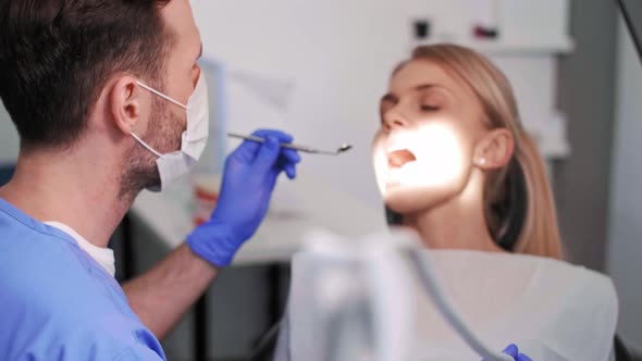 Dentist using dental drill and dental mirror