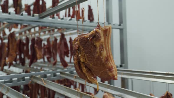 A Lot of Appetizing Smoked Meat Snacks Hang in the Refrigerator Warehouse