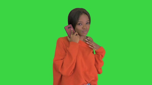 Pretty African American Woman in Bright Jumper Talking on the Phone and Gesturing Emotionally on a