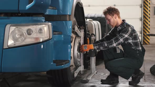 Car Mechanic Repairing Truck Tyres at Car Service