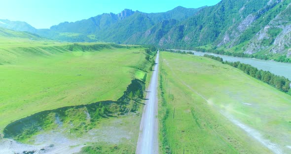 Aerial Rural Mountain Road and Meadow at Sunny Summer Morning