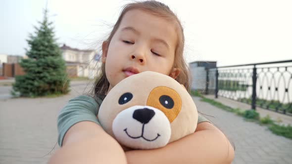 Pretty Little Asian Girl with Dog Makes Selfie on Embankment