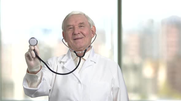 Senior Old Doctor with a Stethoscope in the Right Hand.