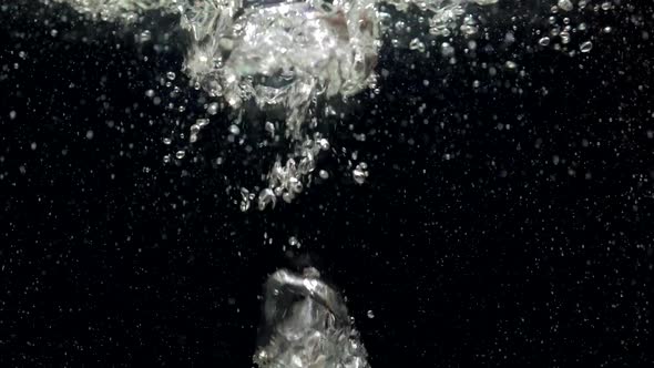 Slow Motion Air Bubbles in Water Rising Up to the Surface on Black Background